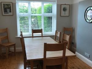 Un comedor con mesa y sillas de madera. en Barreg, en Barmouth