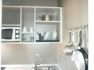 cocina con fregadero y estante con utensilios en Apartamentos Jorbar, en El Arenal