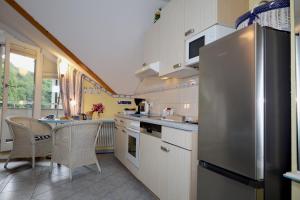 a kitchen with a stainless steel refrigerator and a table at Villa Strandperle, App 18 - nur 20m zum Strand, TOPLAGE in Binz