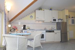 a kitchen with white cabinets and a table and chairs at Villa Strandperle, App 18 - nur 20m zum Strand, TOPLAGE in Binz