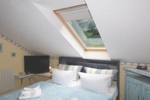 a bedroom with a bed with white pillows and a window at Villa Strandperle, App 18 - nur 20m zum Strand, TOPLAGE in Binz