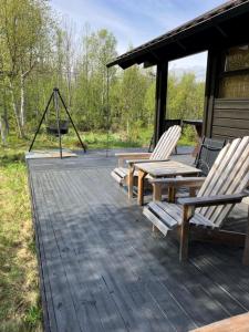 two chairs and a picnic table on a deck at Ski in ski out in Geilo, comfortable and family friendly cabin in Geilo