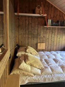 a bed with pillows in a room with wooden walls at Ski in ski out in Geilo, comfortable and family friendly cabin in Geilo +14 photos