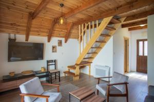 a living room with a staircase and a tv at House Maša in Žabljak