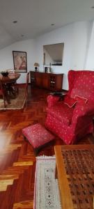 een woonkamer met een rode bank en een tafel bij El Ático de Frida in Vigo
