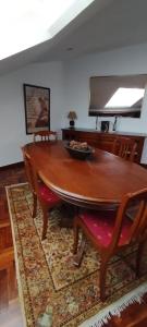 een houten tafel met stoelen en een kom erop bij El Ático de Frida in Vigo