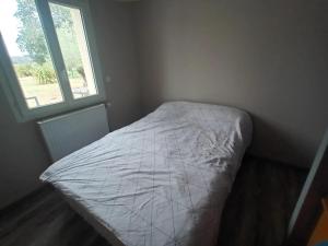 RuaudinにあるLocation chambre à 5 min du circuit des 24 H du Mansの窓付きの部屋の角にあるベッド1台