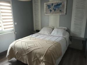 RuaudinにあるLocation chambre à 5 min du circuit des 24 H du Mansの毛布がかけられたベッドのある寝室