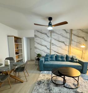 a living room with a blue couch and a table at Cismigiu Bucharest Central 2 bedrooms Apartment in Bucharest