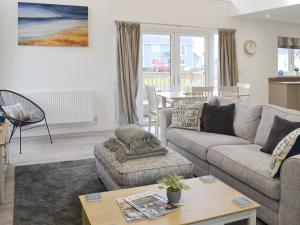 ein Wohnzimmer mit Sofa und Tisch in der Unterkunft Dune View in Beadnell