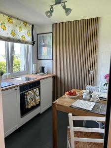 a kitchen with a table and a stove and a sink at Wohnen im Grünen - direkt am Jakobsweg in Overath