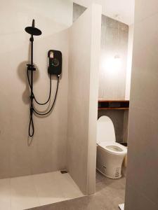 a bathroom with a toilet and a light on the wall at Cozy Cottage by Chanita in Suan Phung +91 photos