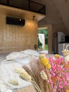 a bed with a bunch of flowers on it at Tatra Glam Krynica Zdrój - Sieć noclegowa Tatra Glamp in Czyrna +21 photos