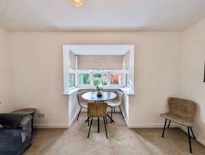 a dining room with a table and chairs and a window at Charming and Modern 1-Bedroom Flat in Slough