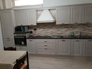 a kitchen with white cabinets and a stove top oven at HomeSweetHome in Salento in Veglie +3 photos