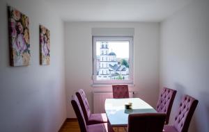 a dining room with a table and chairs and a window at Apartman Milica in Doboj