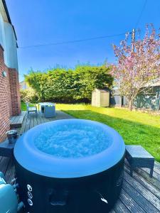 a large hot tub sitting on a deck at Three Bed Detached Home - Large Garden - Hot Tub - Free Parking - Close to Beach! in Iford