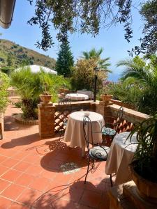 two tables with white table cloths on a patio at Casa dei sogni in Taormina