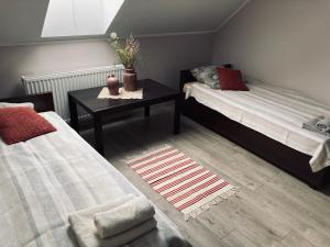 a room with two beds and a table with a table at Kamienica pod Rakiem in Żmigród