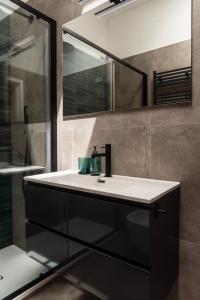 une salle de bain avec un lavabo et un miroir dans l'établissement Youhosty - Zanella 68, à Milan 24 autres photos