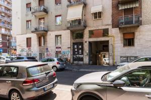 un groupe de voitures garées devant un bâtiment dans l'établissement Youhosty - Zanella 68, à Milan