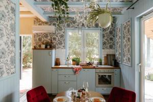 a kitchen with a table and chairs and a kitchen with blue walls at W Lesie Zaklęty in Budy Grabskie