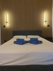a large bed with two blue pillows on it at Nissi Avenue Studios in Ayia Napa
