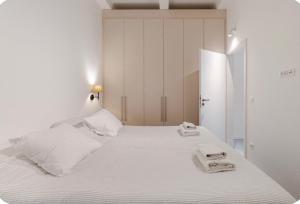 a white bedroom with a large bed with towels on it at Niva 2- stunning sea view 2 bedroom apartment in Dubrovnik