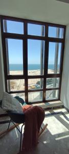 a room with a chair and a large window at Buarcos&Sea Accommodation - Cristal Mar - Your Panoramic Ocean View Retreat in Figueira da Foz