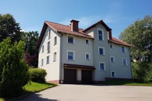 a large white house with a garage at Apartament Marzenie in Kowary