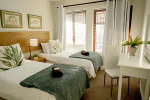 a hotel room with two beds and a window at Fluke Tide - Stylish Knysna Home with Pool & Views in Knysna +31 photos