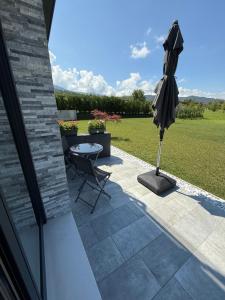 a patio with an umbrella and a table and chair at Nongole 305 in Faverga