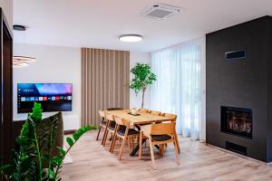 a dining room with a wooden table and chairs at Domček pri golfe in Skalica