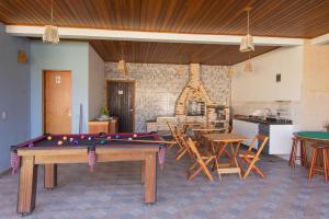 a living room with a pool table and chairs at Hospedaria Morada das Orquídeas Boiçucanga in São Sebastião