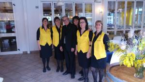 a group of people posing for a picture in a restaurant at Hotel Meublè Villa Patrizia in Grado