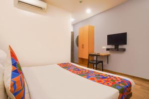 a hotel room with a bed and a tv at FabHotel Cinco in Hyderabad