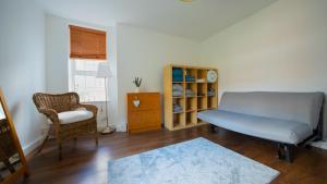a living room with a couch and a chair at Cosy Flat in the Heart of Greenwich in London
