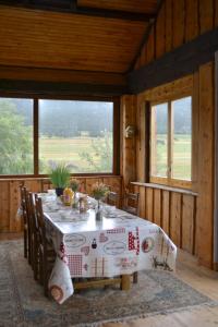 a dining room with a table and some windows at APPARTEMENT MOUFLONS in La Llagonne +29 photos