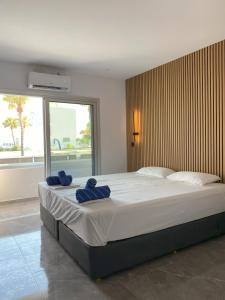 a bedroom with a large bed with blue towels on it at Nissi Avenue Studios in Ayia Napa