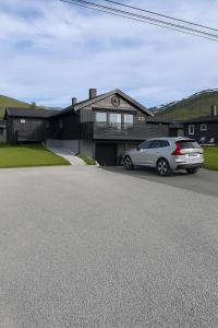 a car parked in front of a house at Modern Apartment with Aurora & Midnight Sun Views, Close to Snow Dome, ski slopes Store & Bus Stop, Free Parking in Tromsø