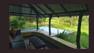a patio with a bench and a swimming pool at Sigiriya Eco Lodge & Accommodation - Sigiriya CES Field Base in Sigiriya