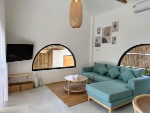Una sala de estar con un sofá azul y una mesa. en Boho Village, en Ko Pha Ngan