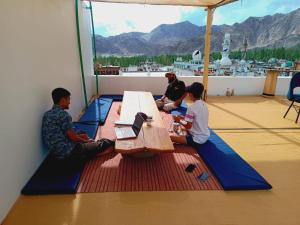 a group of people sitting at a table on a deck at Hearth and Haven Homestay in Leh +14 photos