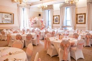 a banquet hall with white tables and chairs at Thomas Arms Hotel in Llanelli