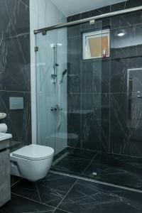 ein Badezimmer mit Toilette und Glasdusche in der Unterkunft Three bedroom in aqua nyali in Mombasa