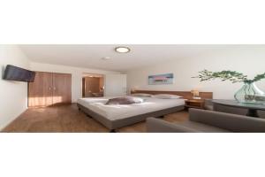 a bedroom with a large bed and a table at Holiday home with whirlpool and sauna in a quiet area in Zeeland in Colijnsplaat