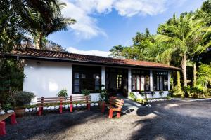 a building with a bench in front of it at Pousada Camury in Garuva