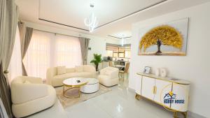 布拉瓦约Hardy House- Kent的客厅里摆放着白色家具，墙上挂着一幅树的画。