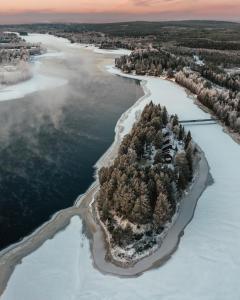 an island in the water with snow on it at Aino Private Island Hotel in Rovaniemi