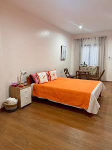 a bedroom with a bed with an orange blanket at The Banahaw Inn Antique - near Antique Airport 